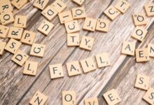 Scrabble tiles on wood form 'FAIL', symbolizing defeat and reflection.