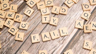 Scrabble tiles on wood form 'FAIL', symbolizing defeat and reflection.