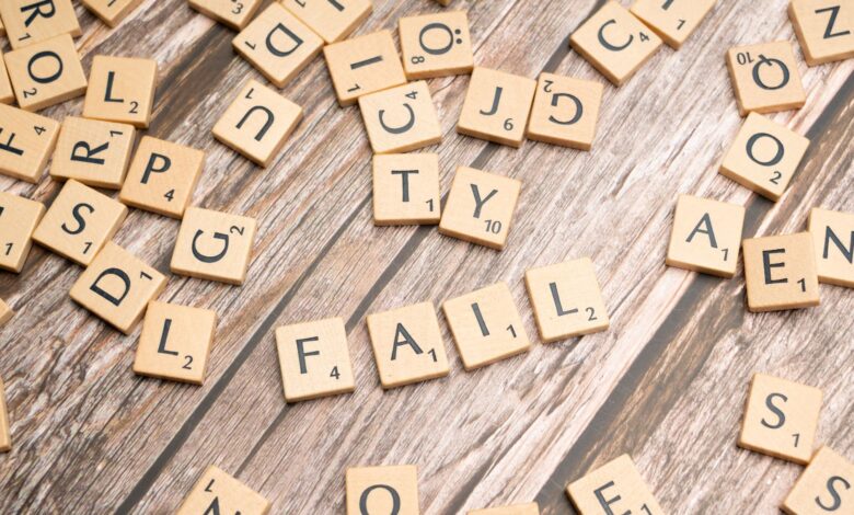 Scrabble tiles on wood form 'FAIL', symbolizing defeat and reflection.