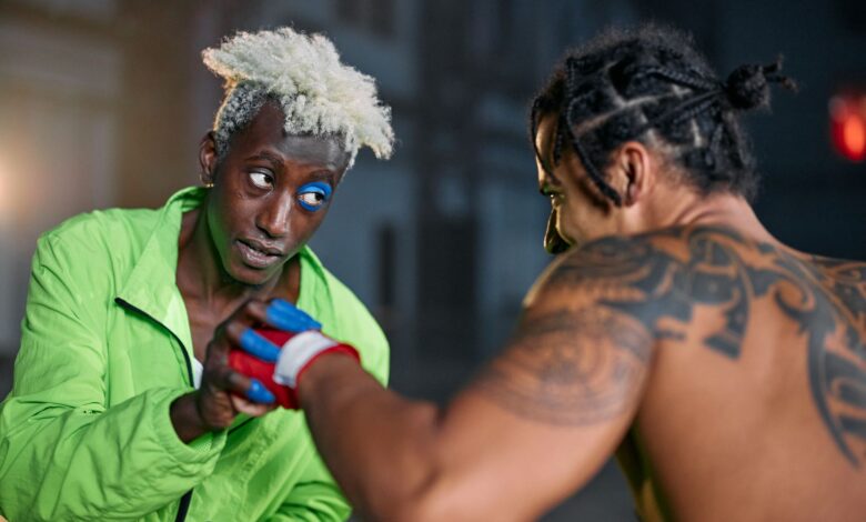 Two martial artists in an intense urban setting, displaying combat skills and tattoos.