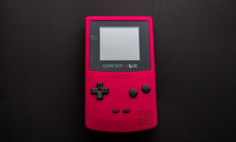 Close-up of a red Nintendo Game Boy Color on a dark backdrop, showcasing retro gaming nostalgia.