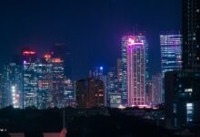 Dynamic cityscape with neon-lit skyscrapers at night, capturing urban energy and vibrant city life.