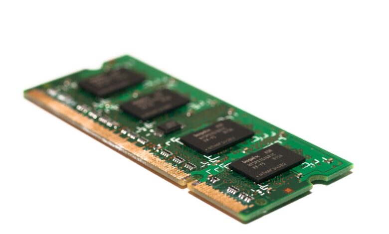 Detailed view of a green electronic memory module against a white background, showcasing modern technology.