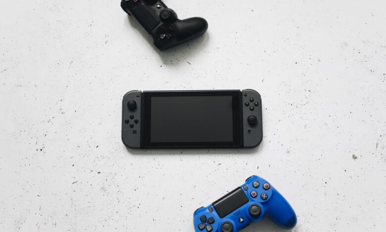 Flat lay of gaming consoles and controllers on white surface, featuring popular gaming devices.