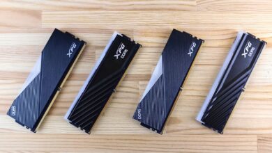 Four XPG DDR5 RAM modules aligned on a wooden surface, showcasing modern computing technology.
