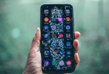 Crop anonymous person using mobile phone with various apps for social network and internet