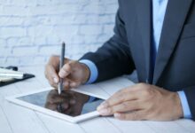 Man in suit using stylus on tablet for business work indoors