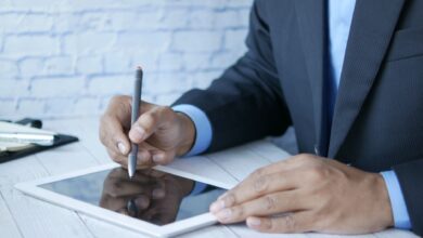 Man in suit using stylus on tablet for business work indoors