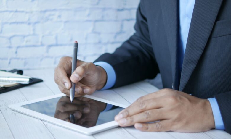 Man in suit using stylus on tablet for business work indoors