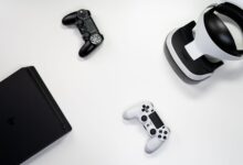 Flat lay of gaming console, controllers, and VR headset on a white background.