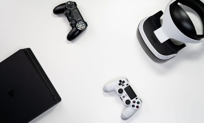 Flat lay of gaming console, controllers, and VR headset on a white background.