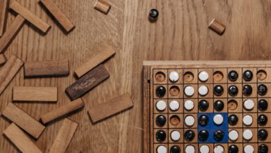 Flat lay of a strategy board game with wooden pieces and a game board on a wooden table.