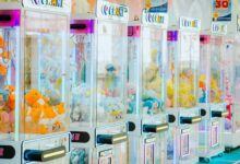 Colorful arcade claw machines filled with plush toys in a bright gaming center.