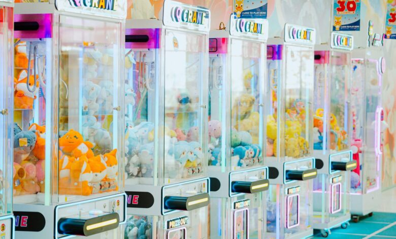 Colorful arcade claw machines filled with plush toys in a bright gaming center.