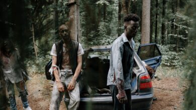 Chilling scene of zombies near an abandoned car in a dense forest.