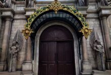 Grand entrance with intricate gold arch and angelic statues adorn the facade.