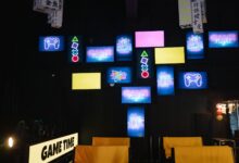 A lively gaming room displaying bright neon signs and screens, creating an immersive atmosphere.