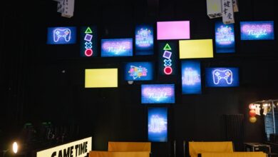 A lively gaming room displaying bright neon signs and screens, creating an immersive atmosphere.