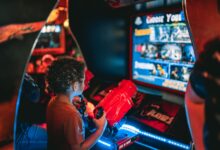 Young child playing an arcade game at an amusement center indoors.