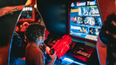 Young child playing an arcade game at an amusement center indoors.