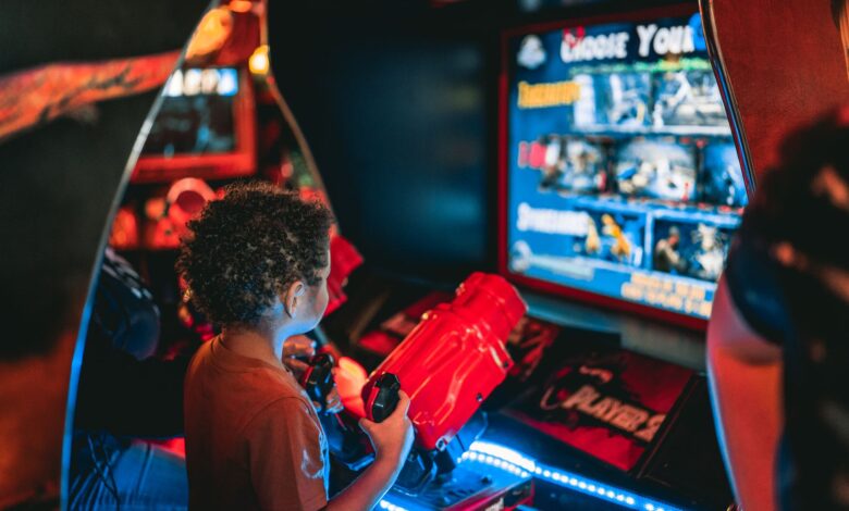 Young child playing an arcade game at an amusement center indoors.