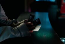 Moody image of a person holding cinema tickets at night, highlighting anticipation of a movie night.