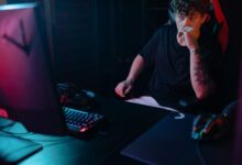 Young man intensely focused on a gaming session at night, highlighting the competitive esports atmosphere.
