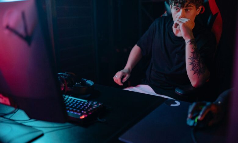 Young man intensely focused on a gaming session at night, highlighting the competitive esports atmosphere.