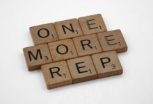 Scrabble tiles arranged to spell 'One More Rep', symbolizing fitness motivation.