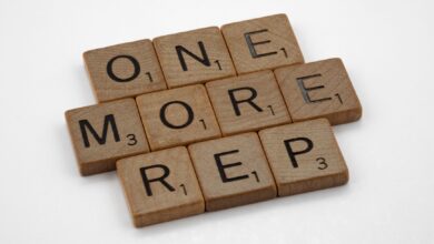 Scrabble tiles arranged to spell 'One More Rep', symbolizing fitness motivation.