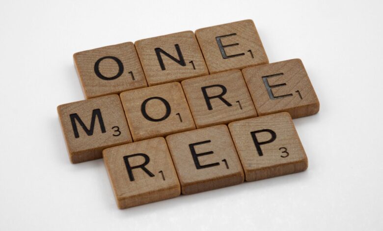 Scrabble tiles arranged to spell 'One More Rep', symbolizing fitness motivation.