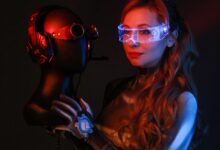 Woman in sci-fi costume holding a helmet with futuristic LED light goggles in a studio setting.
