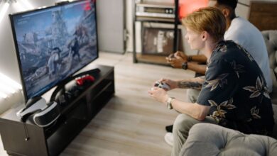 Two friends immersed in playing video games together in a cozy living room.