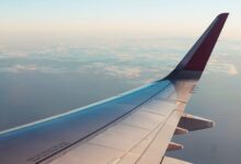 A breathtaking view from an airplane window showcasing clouds and a wing tip over a serene sky.