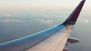 A breathtaking view from an airplane window showcasing clouds and a wing tip over a serene sky.