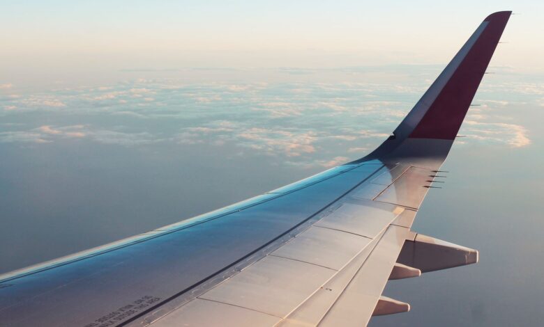 A breathtaking view from an airplane window showcasing clouds and a wing tip over a serene sky.