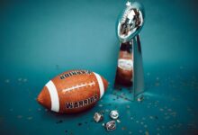 Football and trophy with championship rings on a celebratory background.
