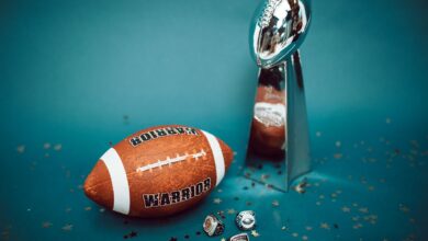 Football and trophy with championship rings on a celebratory background.