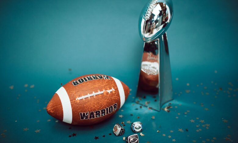 Football and trophy with championship rings on a celebratory background.