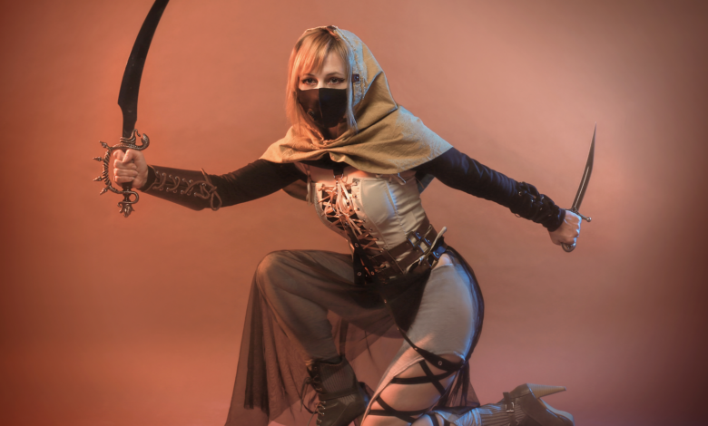 A female warrior in detailed fantasy cosplay, wielding weapons in a studio setting.