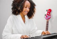A woman in a bathrobe playing an electronic keyboard, showcasing casual indoor leisure.