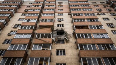 Low-angle view of a damaged apartment building in Kyiv, Ukraine with visible destruction.
