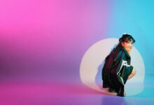 Vibrant studio portrait featuring a young woman surrounded by colorful lighting effects.
