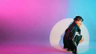 Vibrant studio portrait featuring a young woman surrounded by colorful lighting effects.