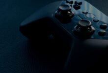 A detailed macro shot of a black game controller with reflections, emphasizing technology and gaming.
