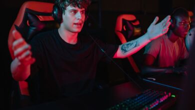 A dynamic image of focused gamers using headsets and RGB keyboards in an esports competition.