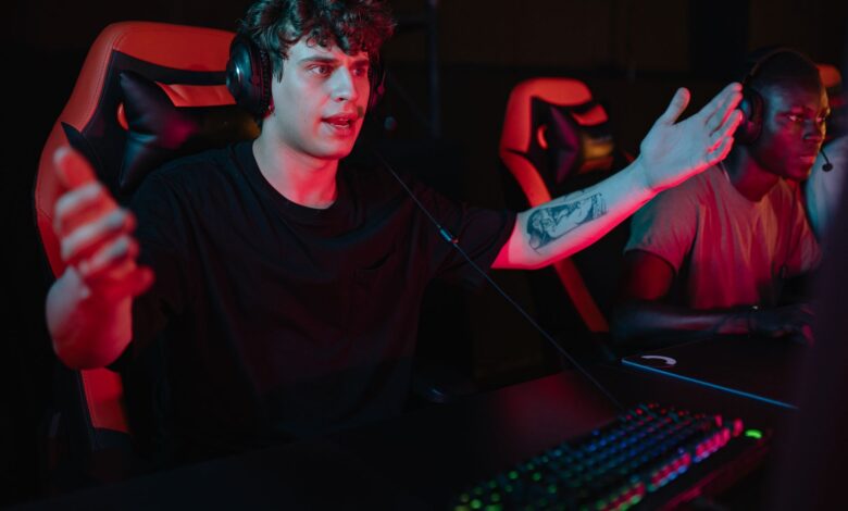 A dynamic image of focused gamers using headsets and RGB keyboards in an esports competition.