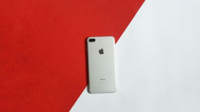 A silver smartphone placed on a contrasting red and white background captured from above.