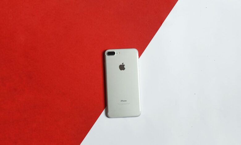 A silver smartphone placed on a contrasting red and white background captured from above.