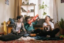 Three kids enjoying a playful and relaxed day inside with snacks and toy guns.